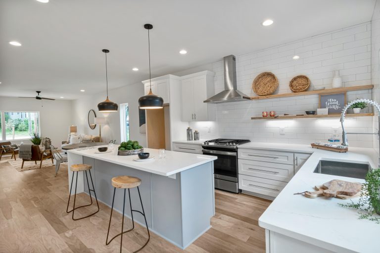 Spacious modern kitchen with island, white cabinets, and sleek lighting for a minimalist interior design.